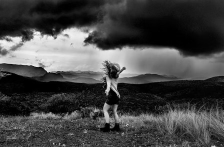woman in a field during a storm